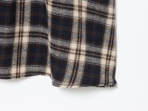 Macro shot of navy blue and cream plaid flannel fabric texture with neat hem stitching