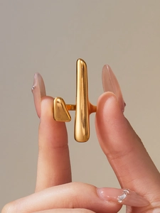 Detail of 18K gold-plated irregular geometric ring with polished mirror finish surfaces