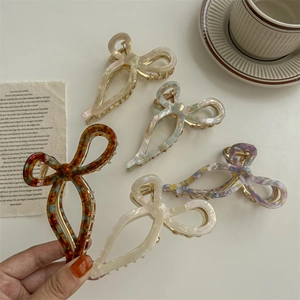 Five assorted acetate bow claw clips in elegant patterns for thick hair styling