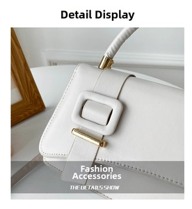 Detail of white PU leather satchel featuring a square buckle and gold hardware