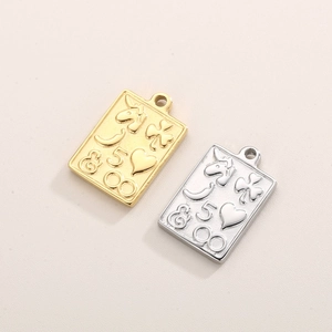 Macro detail of gold and silver rectangular pendants with embossed unicorn and clover motifs
