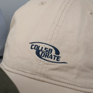 Beige washed cotton baseball cap with blue embroidery detail on front panel