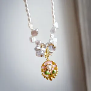Detail of baroque pearl necklace with hand-painted floral enamel pendant in Monet garden style