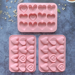 Detailed macro view of pink silicone heart-shaped baking molds with happy text engraving