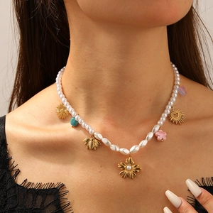 Collier en perles avec pendentifs de tournesol doré et abeille porté par un modèle