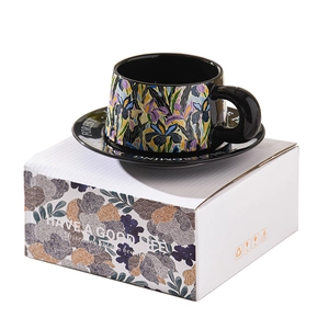 Ceramic coffee cup and saucer set with dark floral patterns and gift box packaging