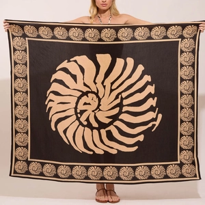 Détail d'un paréo de plage bohème aux motifs de coquillages et spirales noir et beige