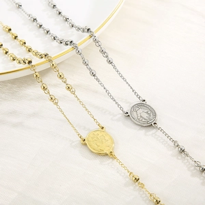 Detail of gold and silver stainless steel cross rosary necklaces with embossed medals