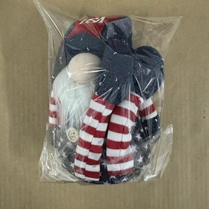 Top view of USA themed gnome doll with red stripes and blue stars in plastic wrap