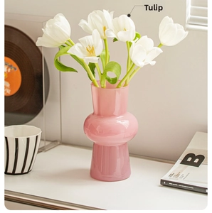 Detailed view of pink double-spherical glass vase with fresh white tulips in home setting
