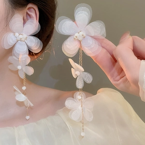 Detail of white chiffon fabric flower earrings with long fringe and pearl accents