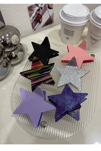 Detailed view of six colorful star-shaped hair claws on a transparent tray