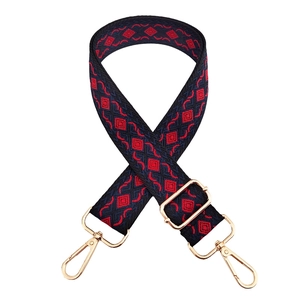 Detail of adjustable geometric diamond pattern wide shoulder strap with gold metal hooks