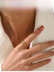 Detailed view of wide 18K gold plated hollow leaf ring with beaded edges on finger