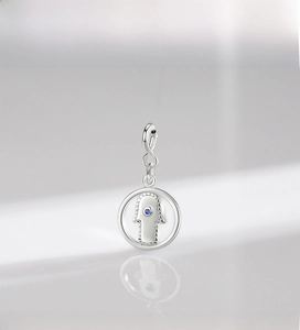 Détail du pendentif Main de Fatima en argent S925 avec pierre bleue sur fond clair