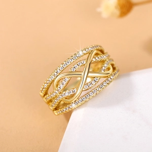 Macro shot of gold infinity ring with pave-set crystals and layered wrap design