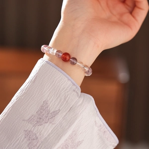 Close-up of white and purple crystal beaded bracelet with red agate on wrist