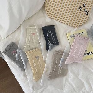 Detail of 6-pack embroidered bow crew socks in various colors with separate zip bags