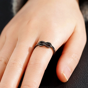 Detailweergave van een zwarte minimalistische infinity ring gedragen aan de vinger