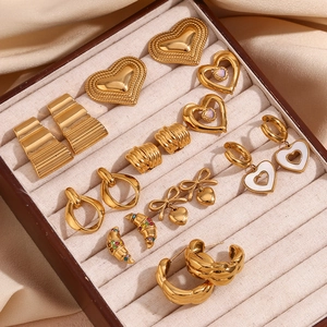 Close-up of assorted 18K gold plated vintage earrings in a beige velvet jewelry box