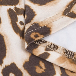 Detailed macro shot of leopard print fabric with precise double-needle hem stitching
