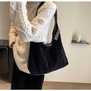 Vintage black suede hobo shoulder bag shown on model wearing white knit sweater