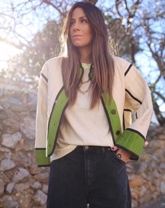 Detailed close-up of cream quilted jacket with contrast green and black trim highlights