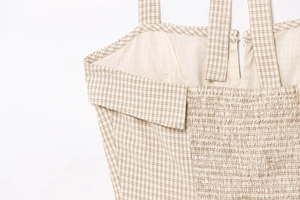 Detail of checkered halter dress showing neck edge, straps and elastic smocked back