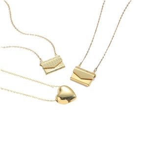 Gold necklaces featuring textured envelope and smooth heart pendants on white background