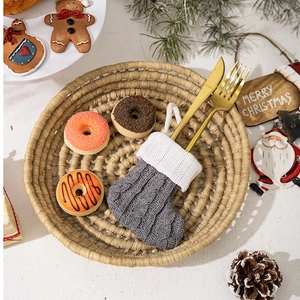 Gray knitted Christmas stocking cutlery holder with golden knife and fork on festive background