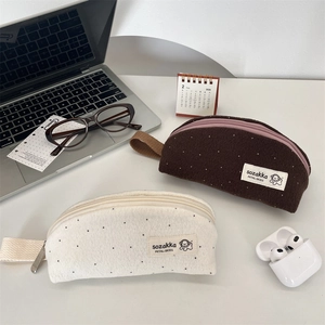 Minimalist wool dot pencil case featuring soft fleece texture and portable side handle strap