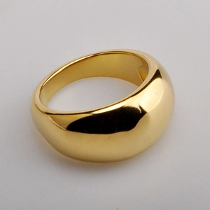 Close-up of a wide polished 18K gold dome ring with a minimalist mirror finish