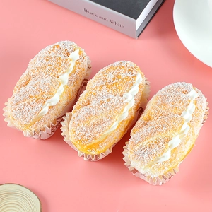 Detailed top view of three artificial cream-filled bread models on a pink background