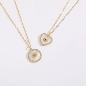 Detailed macro view of evil eye necklaces with heart and round mother of pearl pendants