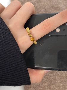 Detailed view of elastic tiger's eye beaded ring with 18K gold-plated metal beads