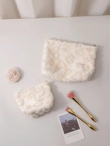 Creamy white plush cosmetic bags with embossed heart patterns for travel storage