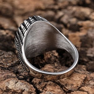 Vintage stainless steel biker ring with embossed texture on rustic wood background