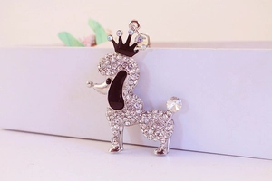 Macro detail of silver puppy keychain with sparkling rhinestones and black crown
