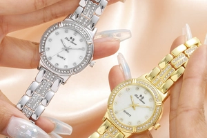 Close-up of luxury women's quartz watches with rhinestone bezels on pink silk fabric