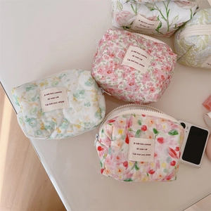Detailed macro view of four quilted floral cotton makeup bags on a soft surface