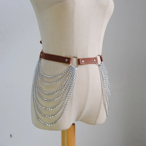 Detail of brown PU leather body chain with multilayered silver punk tassels and ring fasteners