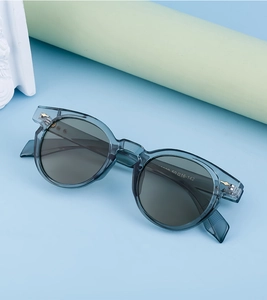Close-up of translucent blue oval sunglasses with metal temple detail and lens specs