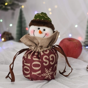 Close-up of a festive red Christmas drawstring gift bag featuring a plush snowman head