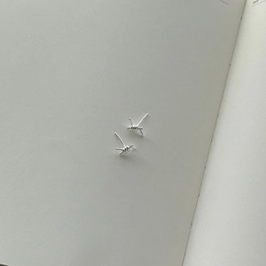Minimalist S925 sterling silver knotted wire stud earrings on a vintage notebook