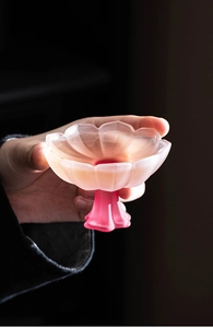 Close-up of a pink gradient petal-shaped glass goblet held to show texture and size