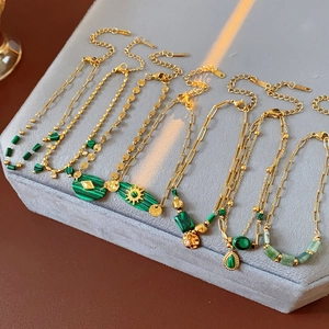Détail de bracelets vintage en acier inoxydable avec breloques en malachite verte