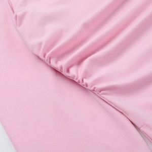 Détail d'un haut rose à manches longues avec fronces élastiques et texture en maille