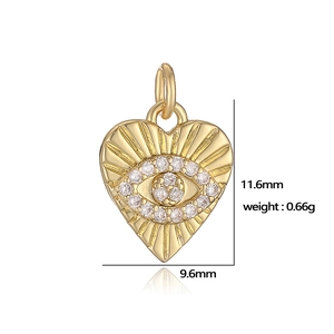 Detailed view of gold heart pendant with evil eye motif and 11.6mm x 9.6mm dimensions