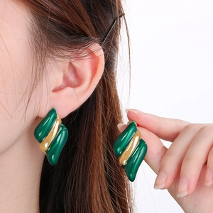 Détail de boucles d'oreilles émaillées ondulées en vert et finition plaquée or 18 carats