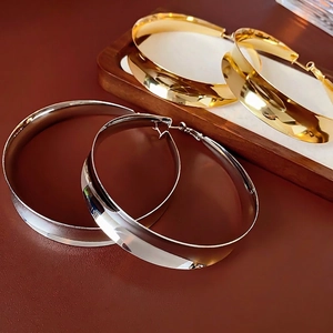 Polished chunky metal hoop earrings set in gold and silver finish with secure clasp